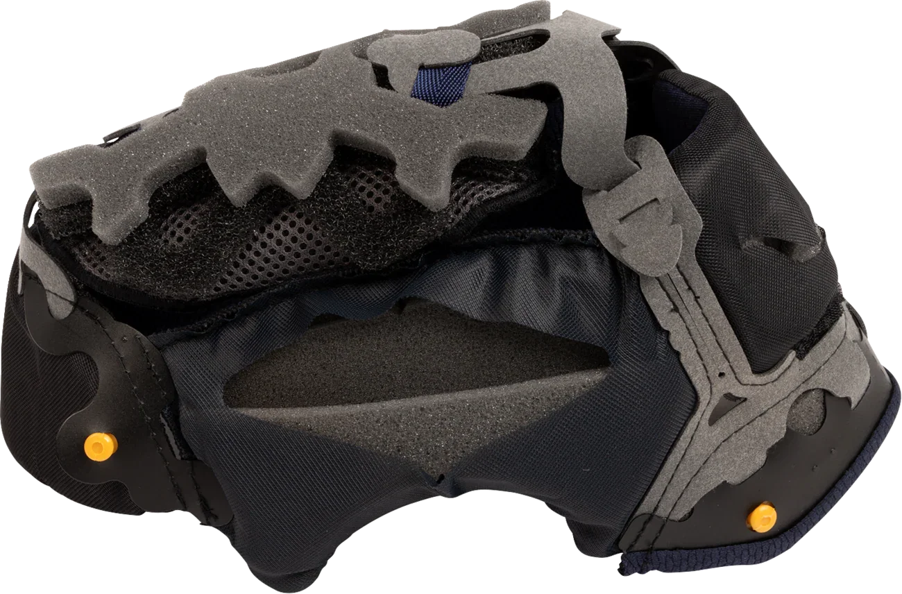 Motorcycle helmet interior with gray foam padding, black mesh lining, and yellow adjustment pins for comfort and fit.